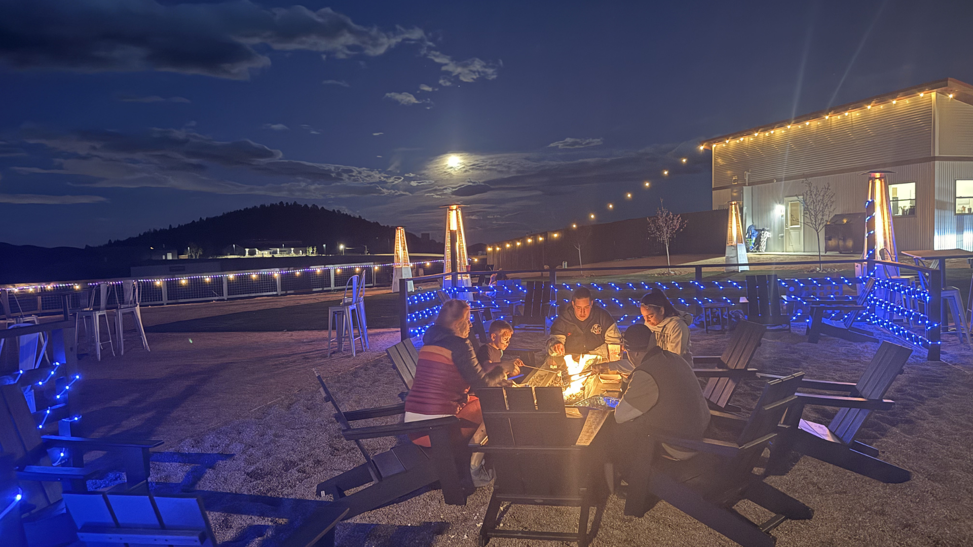 Geodesic glamping domes lit at dusk around a firepit at The Nest at Black Hawk